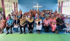 The audience from World NTD Day are sitting down and smiling for a photo. There are many people in the room.