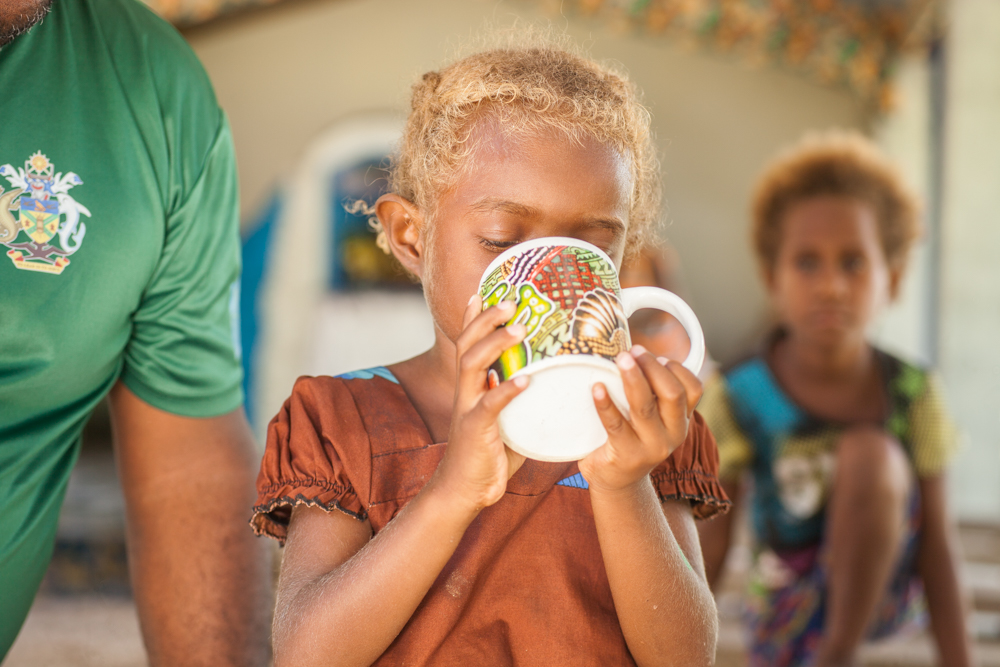 Girl drinking water during MDA, WSP 2022