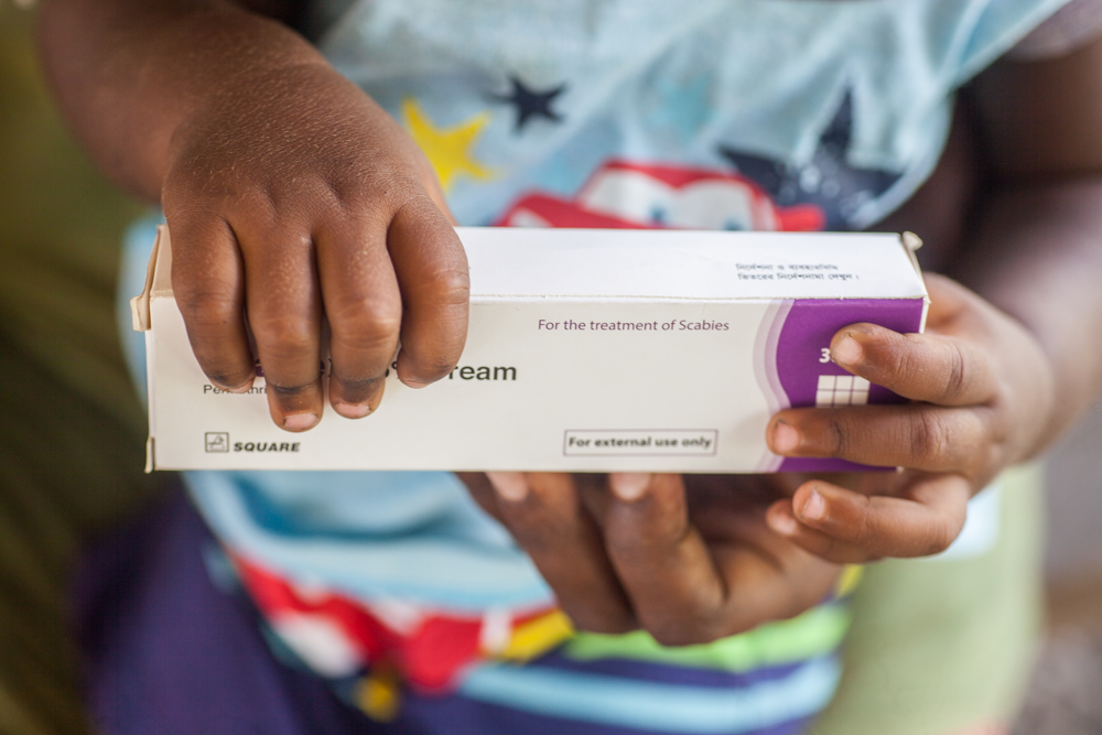 Child holding permethrin cream, WSP 2022