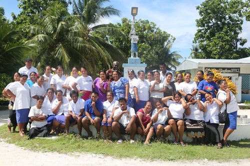A group of training participants stand outside, they are smiling and pulling funny faces.
